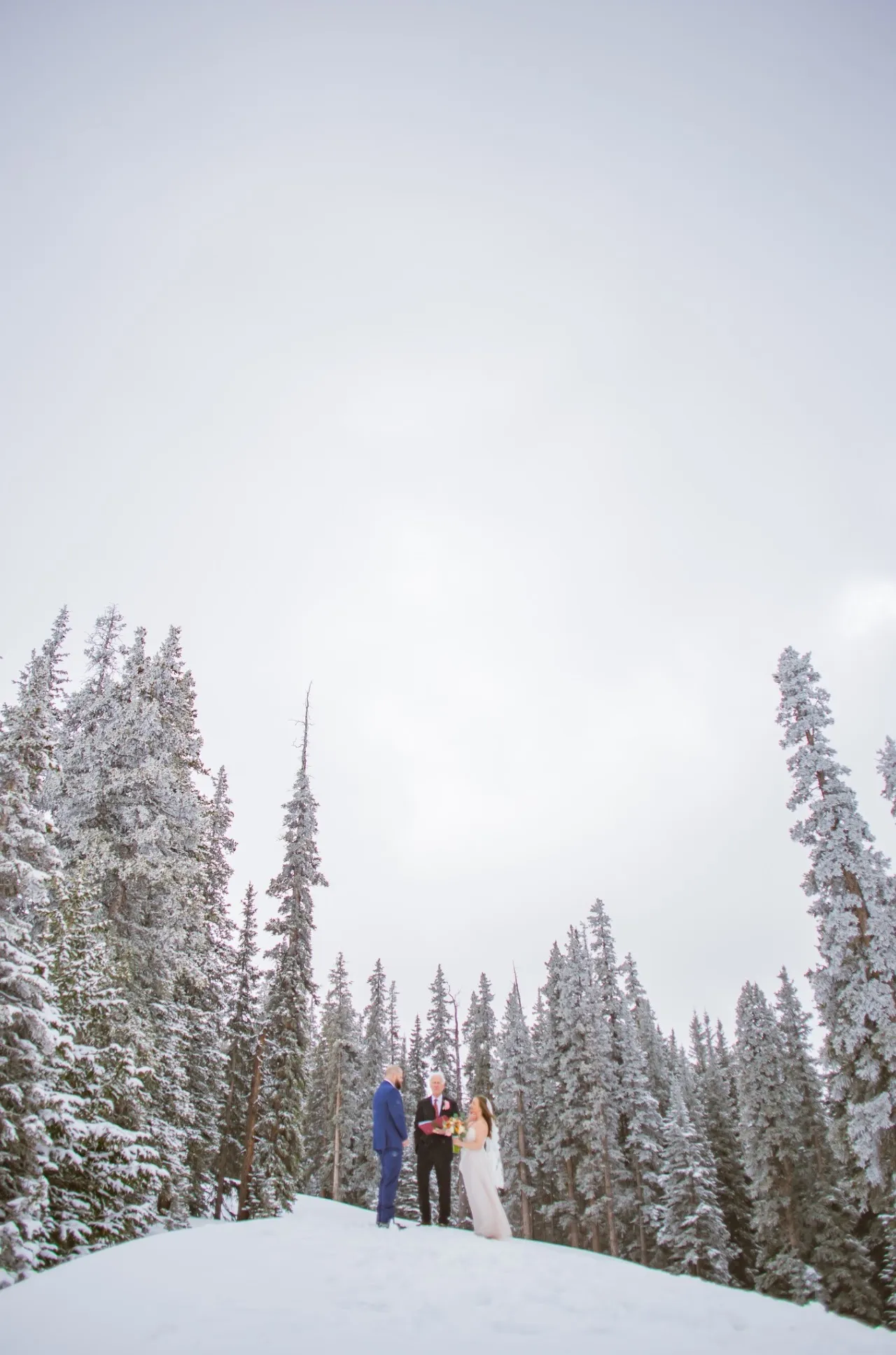 Cinematic landscape of a small wedding ceremony in snow-covered mountains — by Josh Brownlow